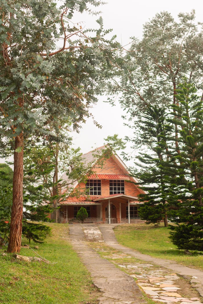 A picturesque brick house surrounded by lush greenery, exemplifying countryside tranquility.